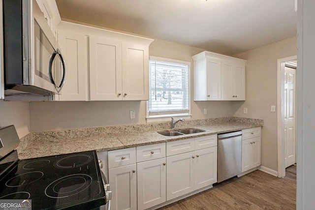 kitchen featuring light stone countertops, sink, white cabinets, and appliances with stainless steel finishes