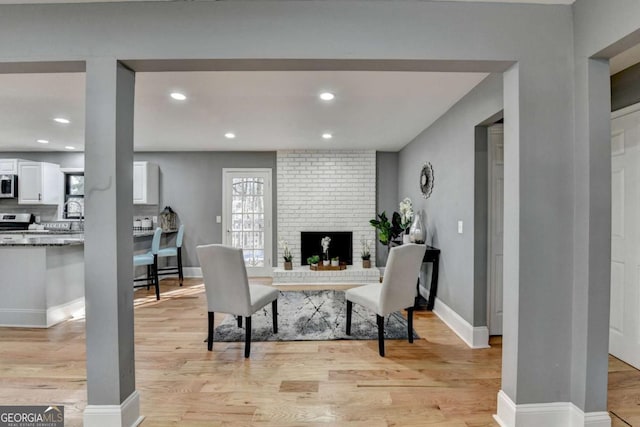 office area featuring light hardwood / wood-style flooring and a brick fireplace