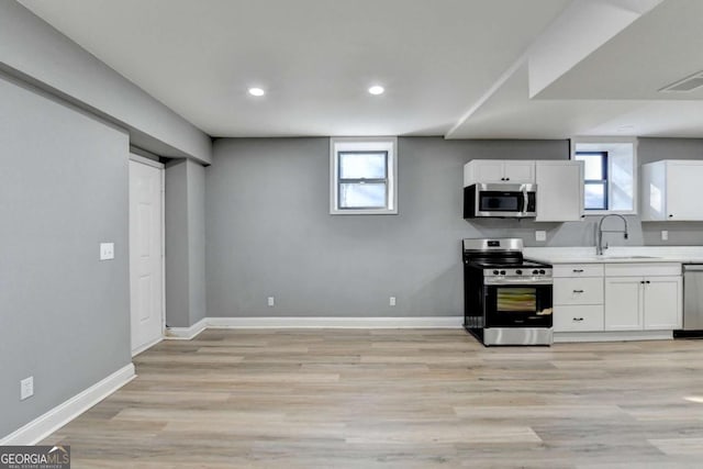 kitchen with plenty of natural light, sink, white cabinetry, and stainless steel appliances