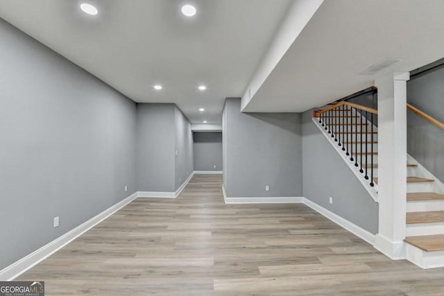 basement with light hardwood / wood-style flooring