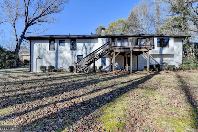 back of property with a yard and a wooden deck