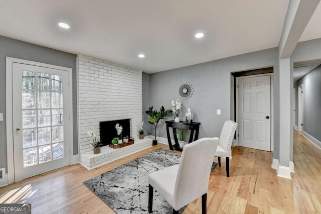 living room featuring a fireplace and light wood-type flooring