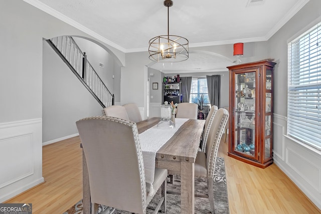 dining room featuring an inviting chandelier, hardwood / wood-style flooring, and ornamental molding