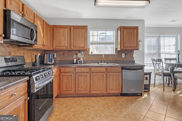 kitchen featuring sink, light tile patterned floors, stainless steel appliances, and decorative backsplash