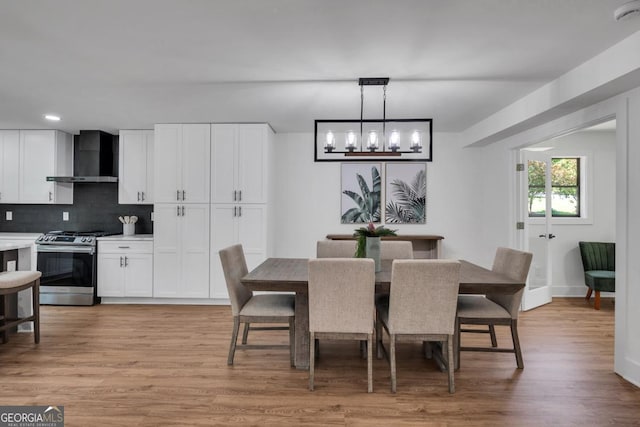 dining space with a notable chandelier and light hardwood / wood-style floors