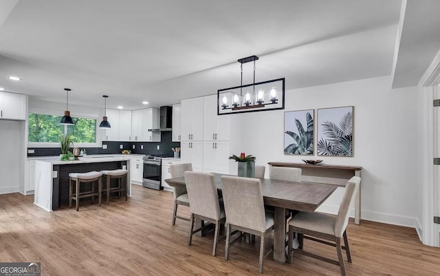 dining space featuring an inviting chandelier and light hardwood / wood-style flooring