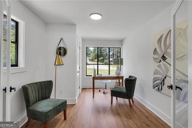 living area with hardwood / wood-style floors, french doors, and a healthy amount of sunlight