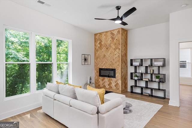 living room featuring ceiling fan, a healthy amount of sunlight, and light hardwood / wood-style flooring