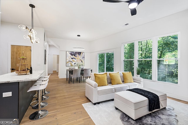 living room with ceiling fan, a wealth of natural light, and light hardwood / wood-style flooring