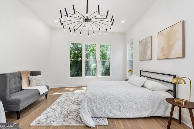 bedroom featuring light wood-type flooring and a notable chandelier