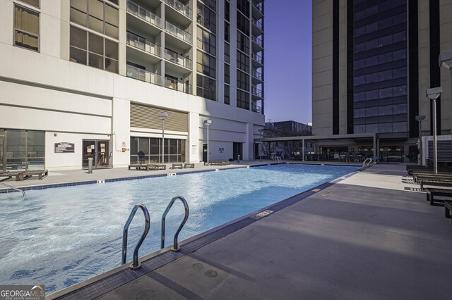 wooden deck with an outdoor living space and a community pool