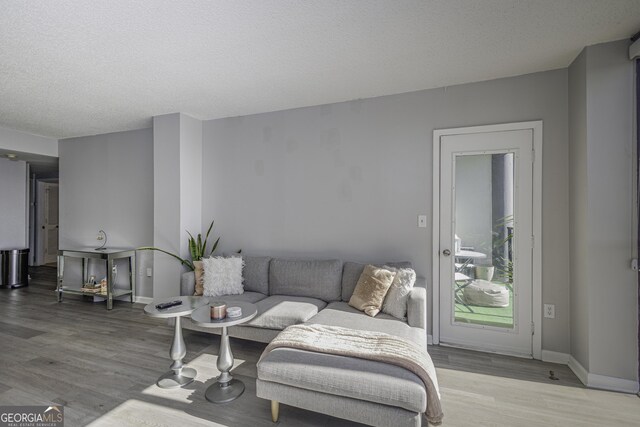 living room featuring hardwood / wood-style floors, a textured ceiling, and a wall of windows