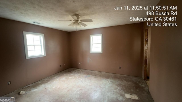 empty room with ceiling fan and a textured ceiling