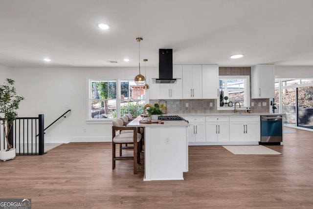 kitchen with white cabinets, island exhaust hood, stainless steel appliances, and hanging light fixtures