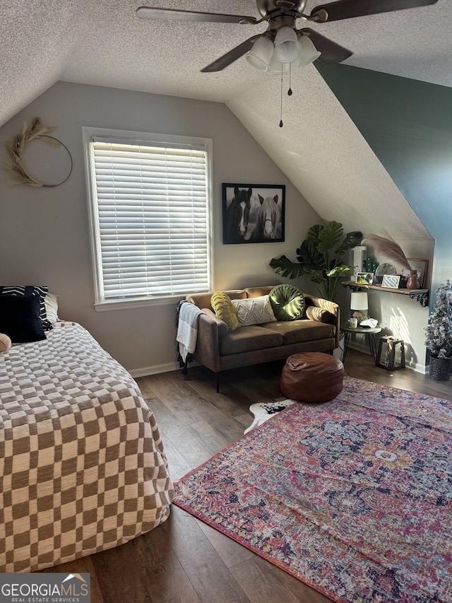 bedroom with ceiling fan, light hardwood / wood-style floors, a textured ceiling, and vaulted ceiling