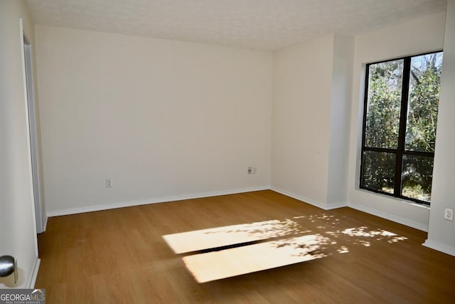 spare room featuring a textured ceiling and hardwood / wood-style flooring