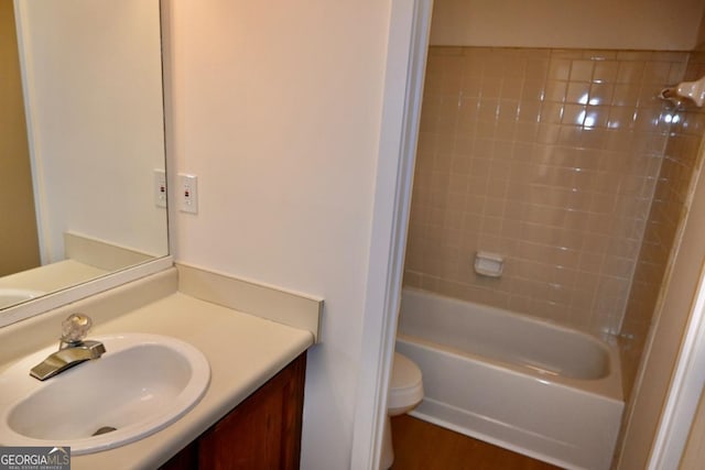 full bathroom with hardwood / wood-style flooring, vanity, tub / shower combination, and toilet