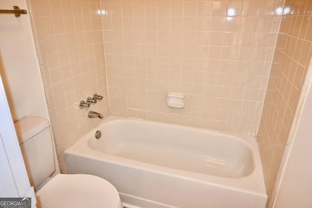 bathroom featuring shower / tub combination and toilet