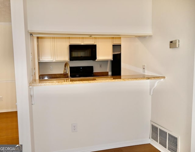 kitchen featuring light stone countertops, dark wood-type flooring, and range