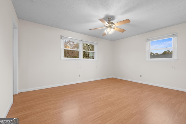 empty room featuring a textured ceiling, light hardwood / wood-style floors, and ceiling fan