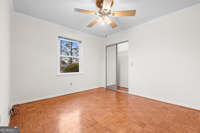 spare room with ceiling fan, crown molding, and light parquet flooring