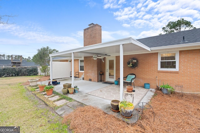 rear view of property with a lawn, ceiling fan, and a patio area