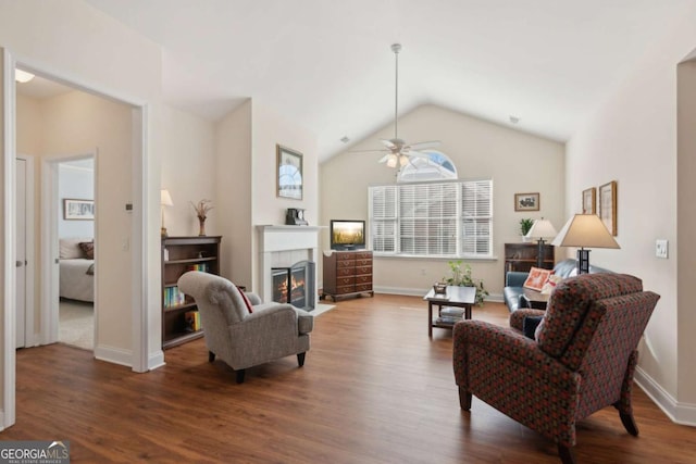 living room featuring a fireplace, dark hardwood / wood-style floors, vaulted ceiling, and ceiling fan