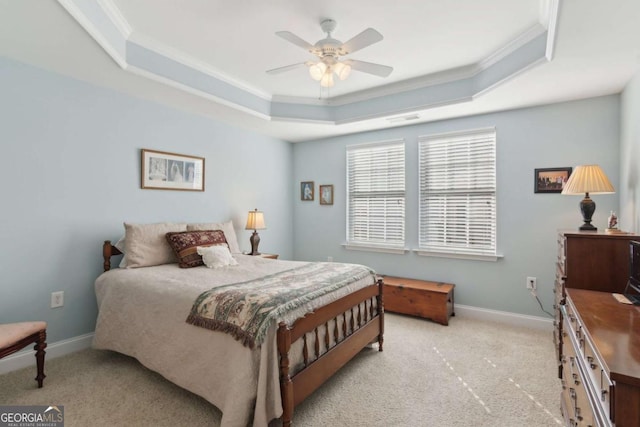 carpeted bedroom featuring a tray ceiling, ceiling fan, and crown molding