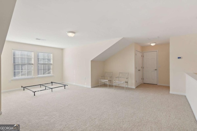 additional living space with light carpet and vaulted ceiling