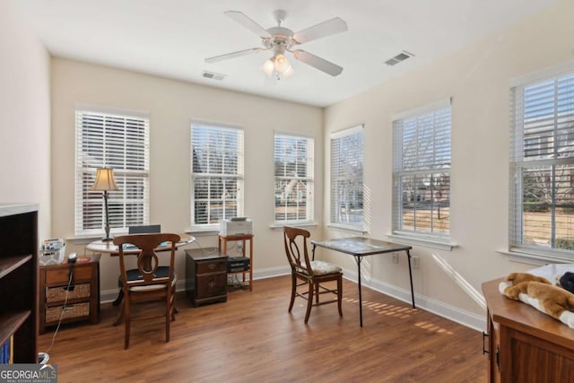 interior space with a healthy amount of sunlight, ceiling fan, and dark wood-type flooring