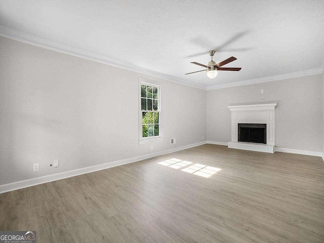 unfurnished living room featuring ceiling fan, crown molding, and a fireplace