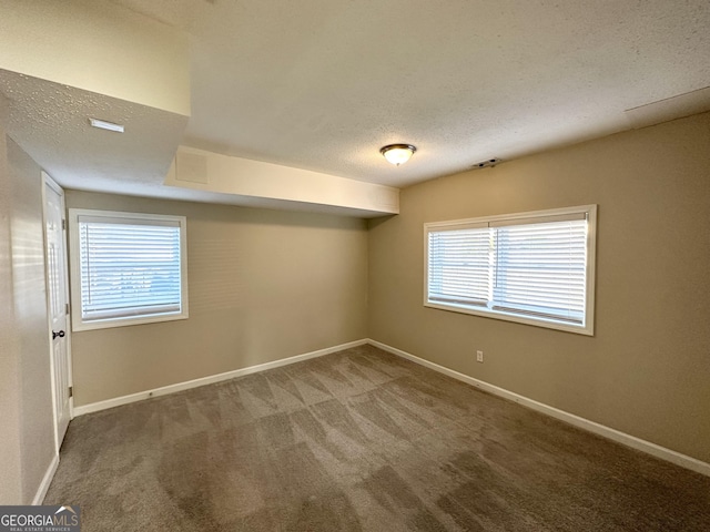 carpeted empty room featuring a textured ceiling