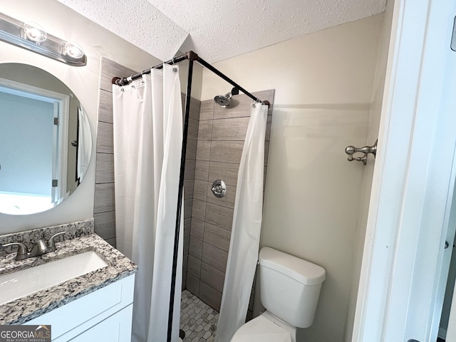 bathroom with toilet, vanity, a textured ceiling, and walk in shower