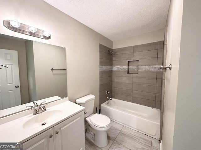 full bathroom featuring tiled shower / bath combo, toilet, a textured ceiling, and vanity