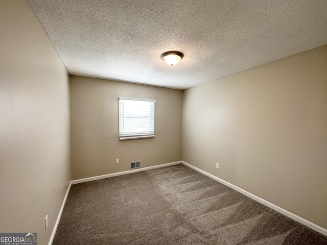 unfurnished room with carpet and a textured ceiling