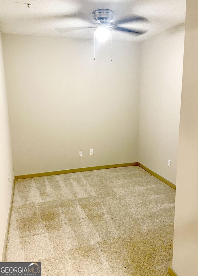 carpeted spare room featuring ceiling fan