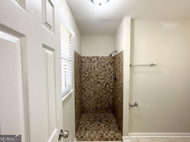 bathroom with a tile shower, tile patterned floors, and a healthy amount of sunlight