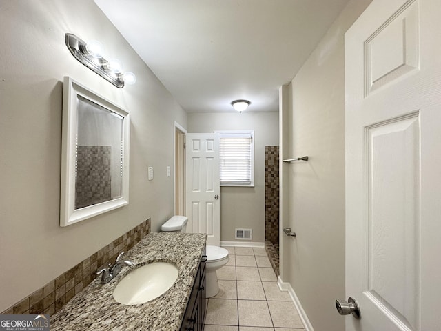 bathroom featuring toilet, vanity, tile patterned floors, and walk in shower