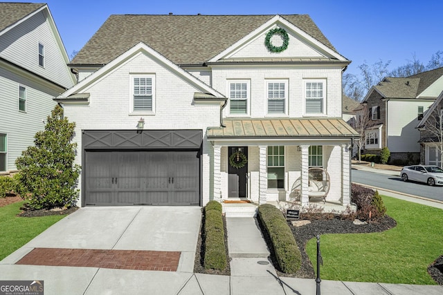 view of front facade featuring a garage, covered porch, and a front lawn