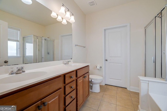 bathroom featuring toilet, vanity, tile patterned floors, and an enclosed shower