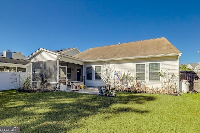 back of house with a lawn, a sunroom, and a patio