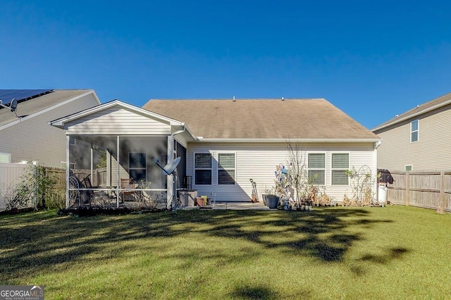 back of property with a yard and a sunroom