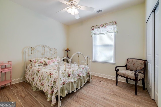 bedroom with light wood-type flooring, a closet, and ceiling fan