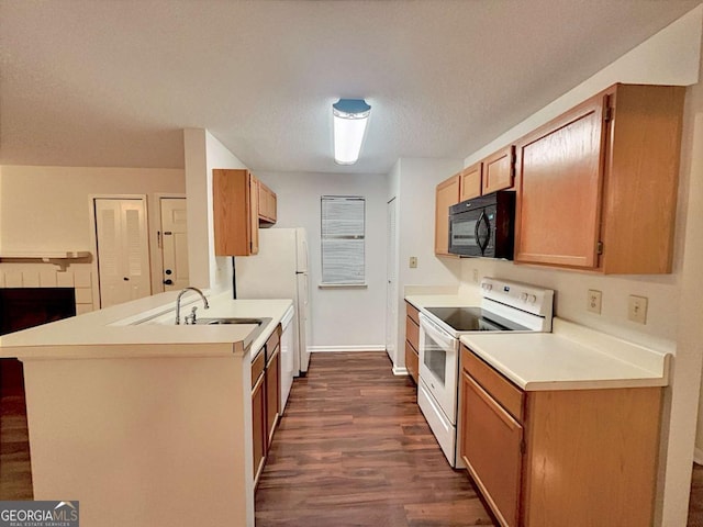 kitchen featuring sink, dark wood-type flooring, white appliances, and kitchen peninsula