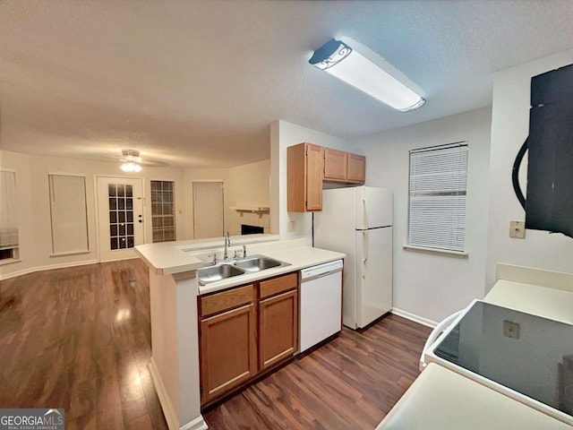 kitchen with dark wood-type flooring, sink, a textured ceiling, kitchen peninsula, and white appliances