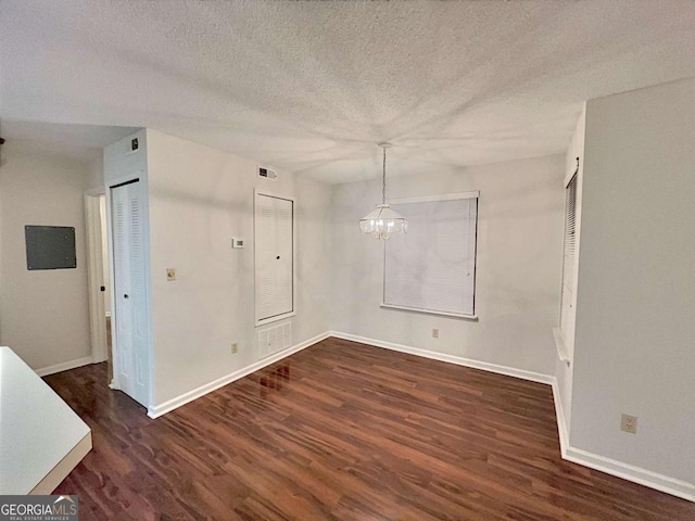 interior space featuring dark hardwood / wood-style flooring, a chandelier, and a textured ceiling