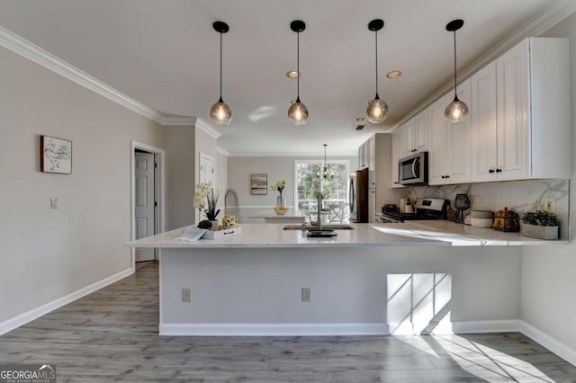 kitchen featuring stainless steel appliances, sink, white cabinetry, ornamental molding, and kitchen peninsula