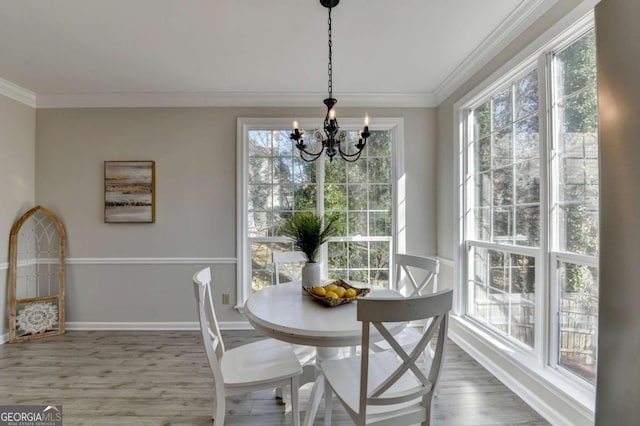 dining space with ornamental molding, an inviting chandelier, and wood-type flooring