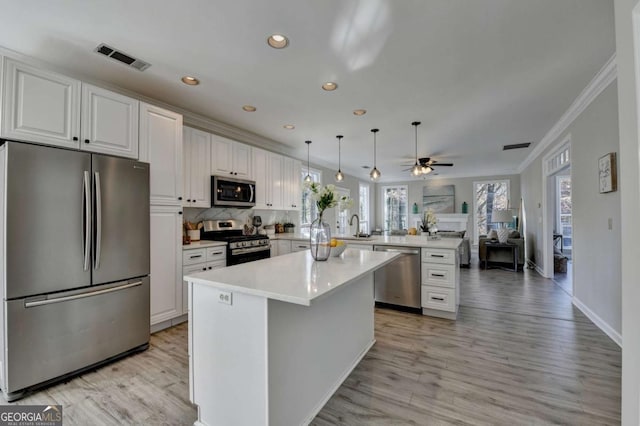 kitchen featuring white cabinets, stainless steel appliances, and kitchen peninsula