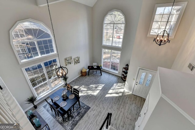 entryway featuring a high ceiling, hardwood / wood-style flooring, and a notable chandelier